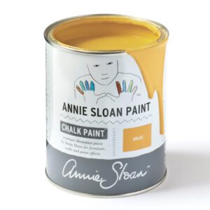 A can of Annie Sloan Chalk Paint in a warm yellow shade.