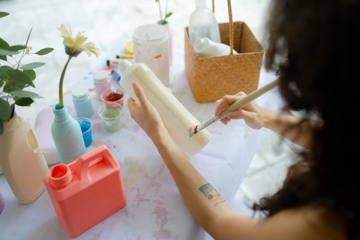 Person painting nails with a brush at a table.